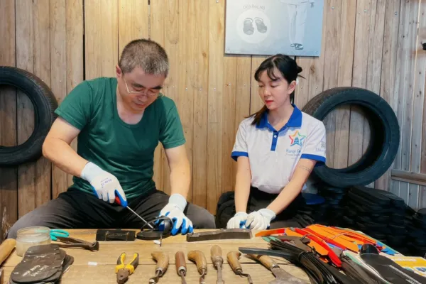 A craftsman making rubber tire sandals in Hanoi