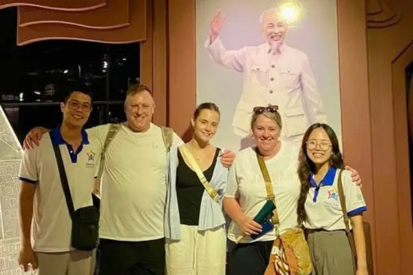A guide explaining a museum exhibit to visitors in Hanoi