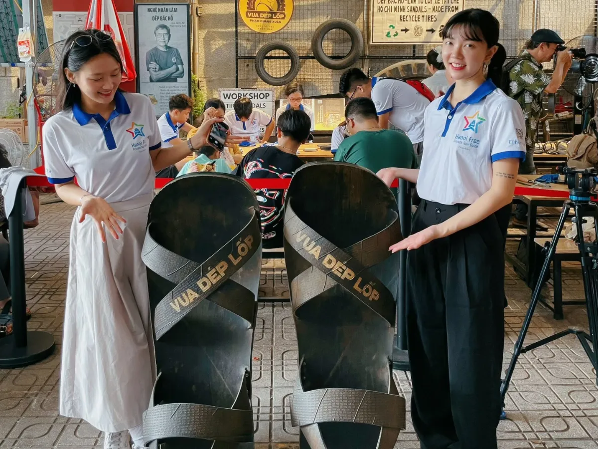 A craftsman cutting a sandal sole from an old tyre at a workshop in Hanoi
